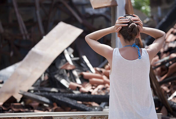 a homeowner looking at whats left of her house that burned down in a house fire.